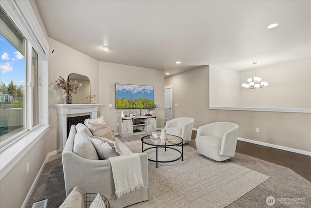living room featuring recessed lighting, baseboards, a chandelier, and a fireplace