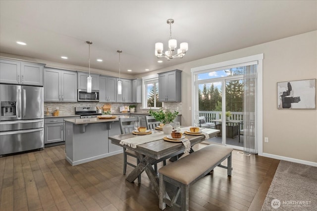 dining space with recessed lighting, baseboards, a notable chandelier, and dark wood-style floors