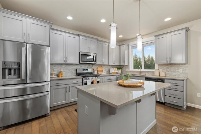 kitchen featuring dark wood-type flooring, decorative backsplash, gray cabinetry, and stainless steel appliances