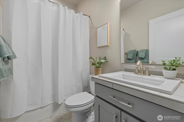 bathroom featuring vanity, shower / bath combo, and toilet