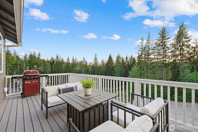 deck featuring area for grilling, outdoor lounge area, and a wooded view