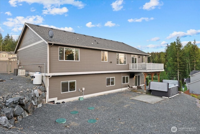 rear view of house with a patio, a wooden deck, and cooling unit