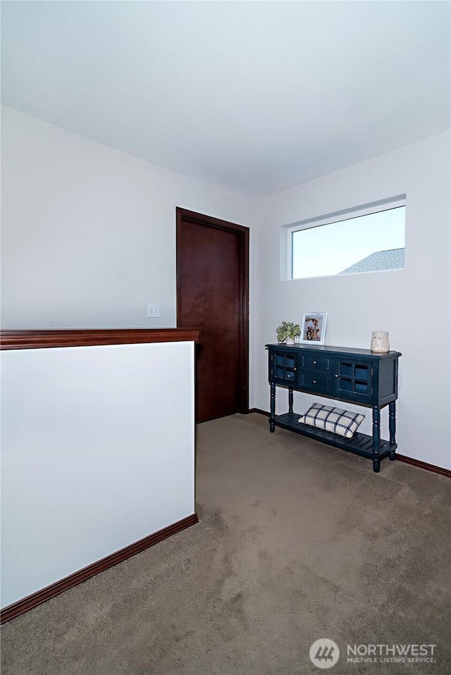 hallway with baseboards and carpet flooring