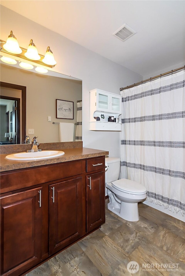 bathroom featuring vanity, a shower with curtain, toilet, and visible vents