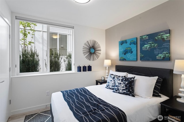 bedroom with baseboards and wood finished floors