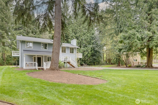 back of property featuring a lawn, stairway, a chimney, and a porch