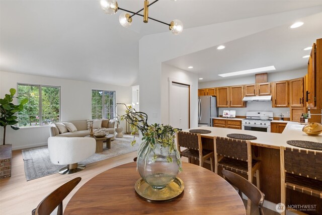 dining area featuring recessed lighting, light wood finished floors, baseboards, and vaulted ceiling