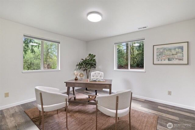 home office with plenty of natural light, baseboards, wood finished floors, and visible vents
