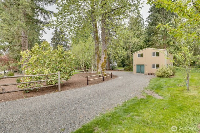 surrounding community with fence, a yard, and driveway