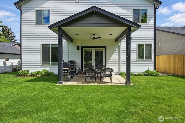 back of house featuring fence, french doors, ceiling fan, a patio area, and a lawn