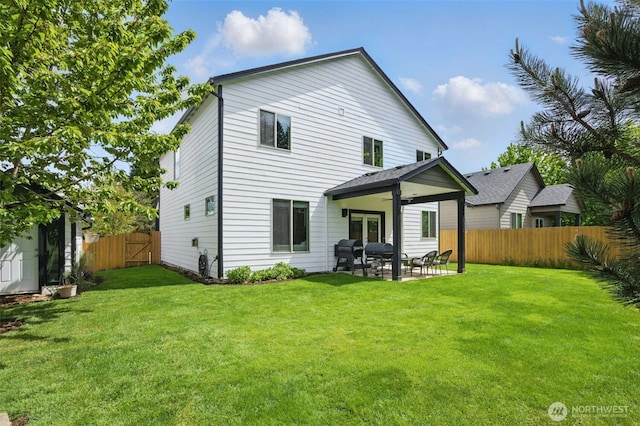 rear view of house with a fenced backyard, a patio, a lawn, and french doors
