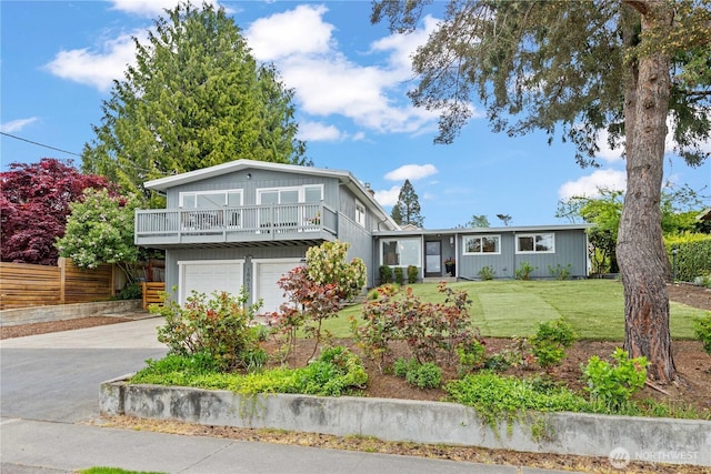 view of front of house with fence, driveway, a front yard, and a garage