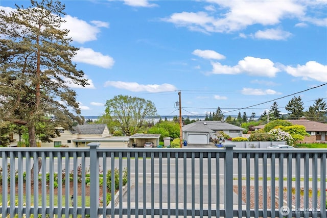 view of gate with fence, an outbuilding, and a residential view