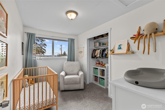 bedroom with a closet, carpet flooring, a crib, and baseboards