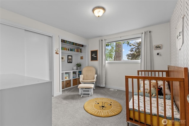 bedroom featuring carpet floors, baseboards, and a nursery area