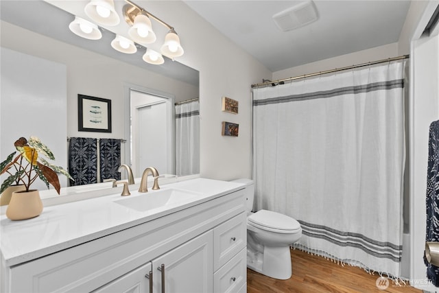bathroom featuring vanity, a shower with curtain, toilet, and wood finished floors