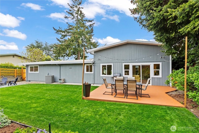 rear view of property featuring a lawn, a deck, cooling unit, and outdoor dining area