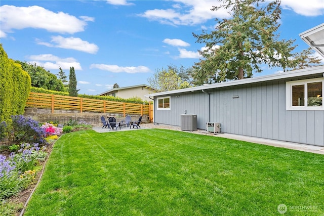 rear view of house featuring central AC unit, a fenced backyard, an outdoor fire pit, a yard, and a patio