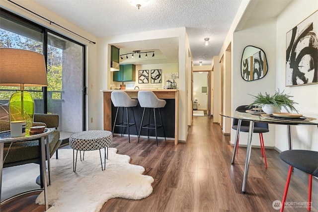 interior space with a textured ceiling and wood finished floors