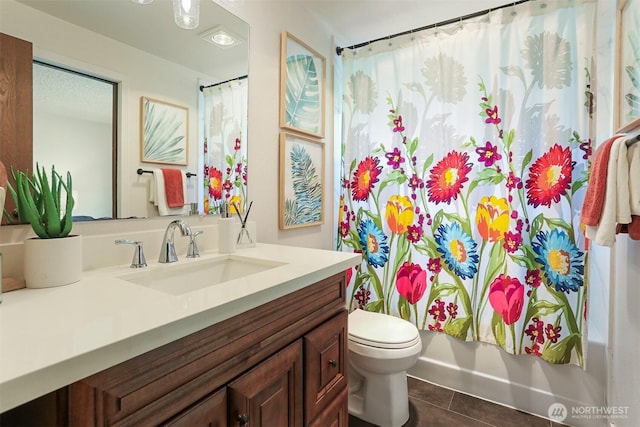 bathroom featuring vanity, tile patterned flooring, and toilet