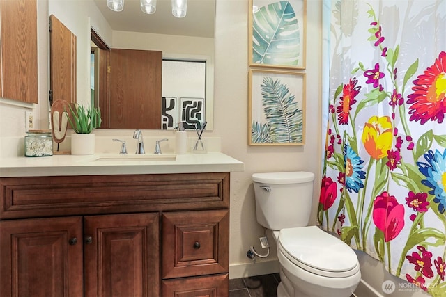 full bath with baseboards, tile patterned floors, vanity, and toilet