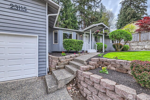 property entrance with a garage and fence