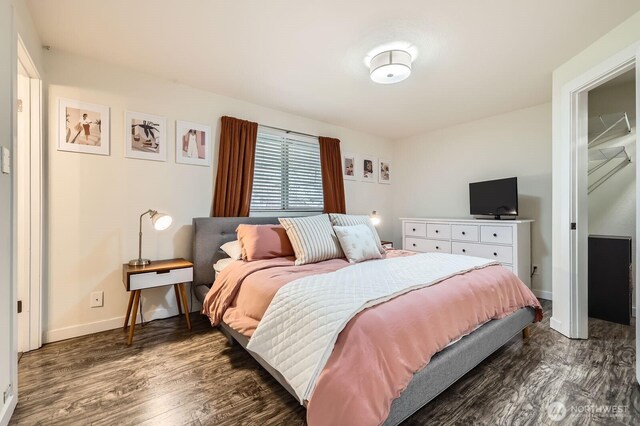bedroom with baseboards and dark wood-style floors