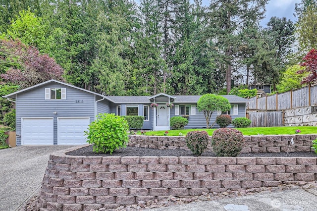 ranch-style home with fence, driveway, and a garage