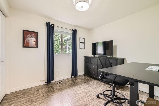 home office with visible vents, baseboards, and wood finished floors