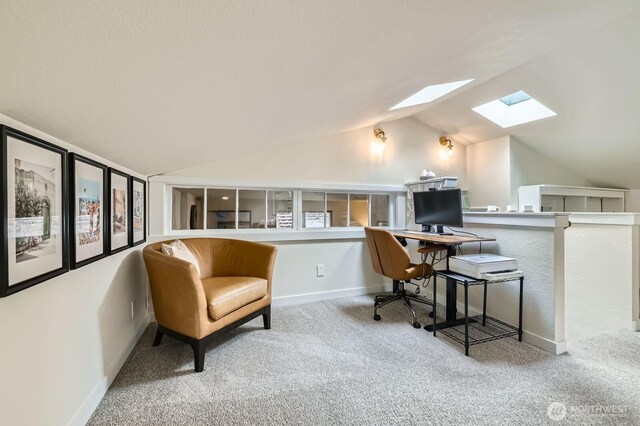 office area featuring baseboards, carpet flooring, and lofted ceiling with skylight