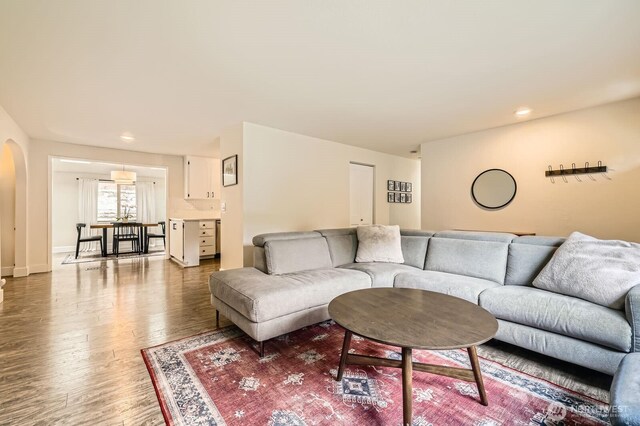 living room featuring recessed lighting, arched walkways, and wood finished floors