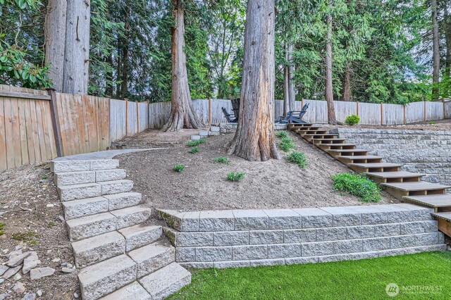 view of yard with stairs and a fenced backyard