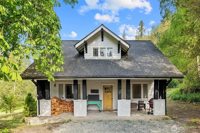 bungalow-style home featuring a porch and a shingled roof