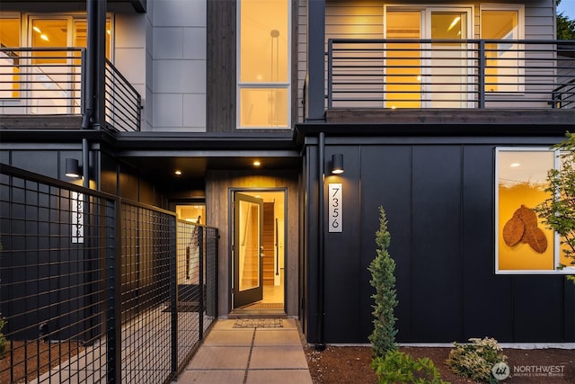 7356 21st Ave NW, Seattle, WA 98117 - doorway to property with board and batten siding, fence, and a balcony