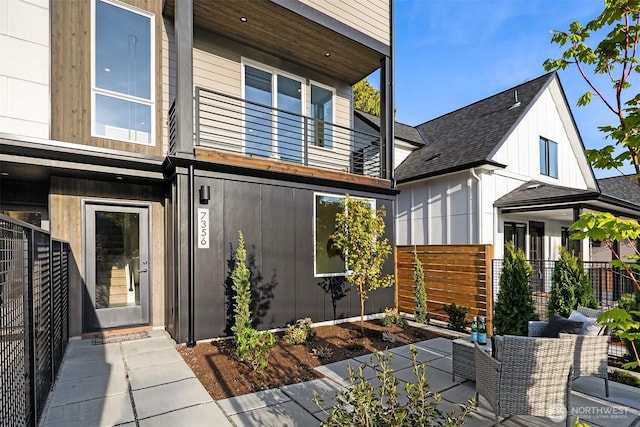 7356 21st Ave NW, Seattle, WA 98117 - view of front facade featuring fence, a shingled roof, and a balcony