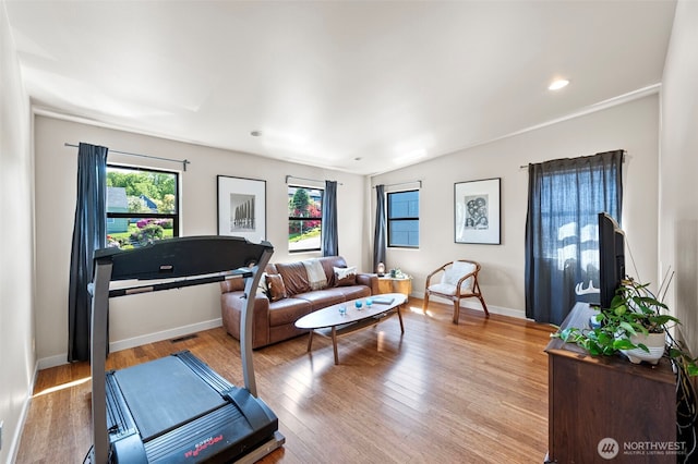 living room with baseboards, light wood-type flooring, and visible vents