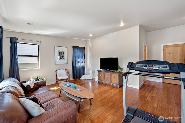 living area with baseboards, recessed lighting, and wood finished floors
