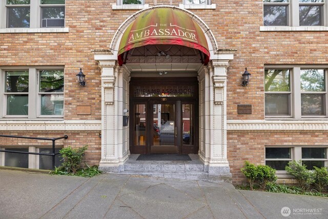 entrance to property featuring brick siding