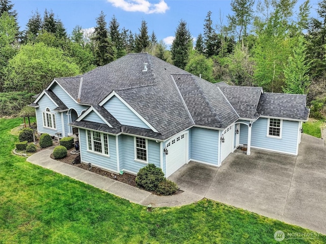 ranch-style house with concrete driveway, a front lawn, roof with shingles, and a garage