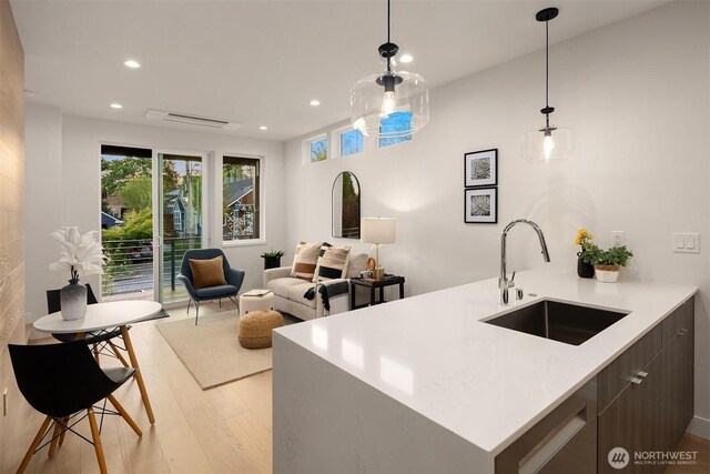 kitchen featuring light countertops, recessed lighting, a sink, and light wood-style floors