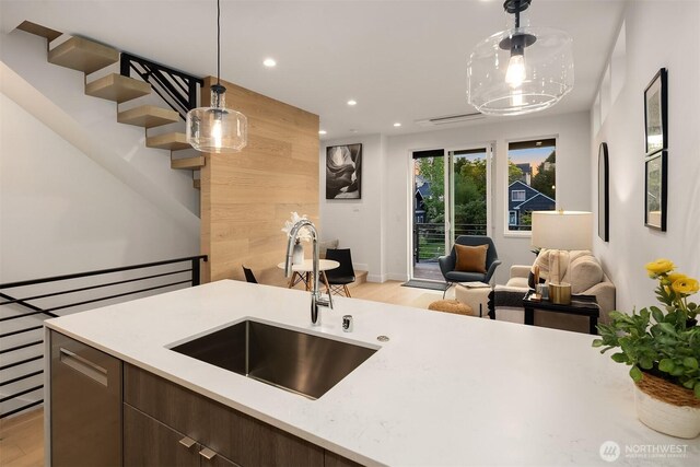 kitchen featuring light wood-style floors, a sink, and light countertops