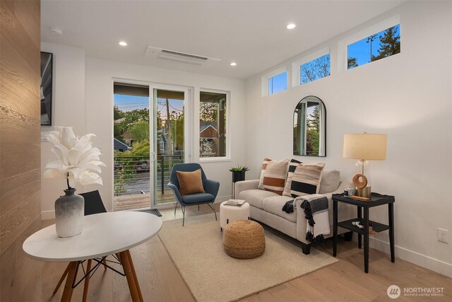living area featuring recessed lighting, baseboards, wood finished floors, and visible vents