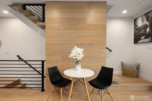 dining room featuring baseboards, recessed lighting, stairs, and wood finished floors