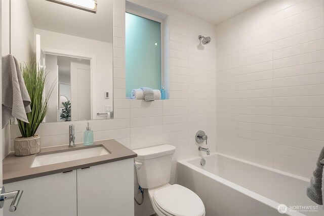 full bath with decorative backsplash, tile walls, vanity, toilet, and washtub / shower combination