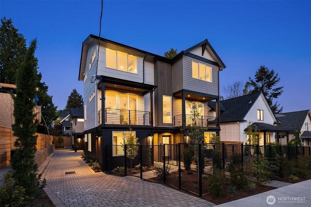 back of property featuring a gate, a fenced front yard, and a balcony