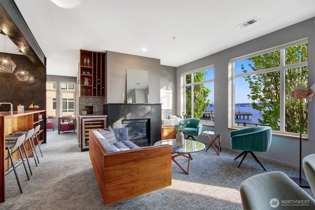 living room with carpet floors, beverage cooler, visible vents, and a fireplace