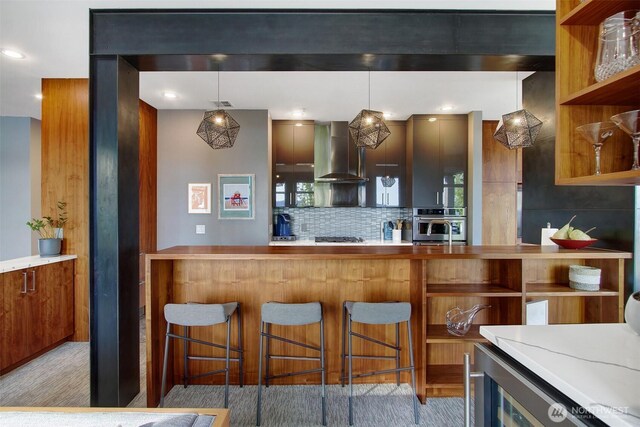 kitchen with wall chimney range hood, modern cabinets, open shelves, tasteful backsplash, and oven