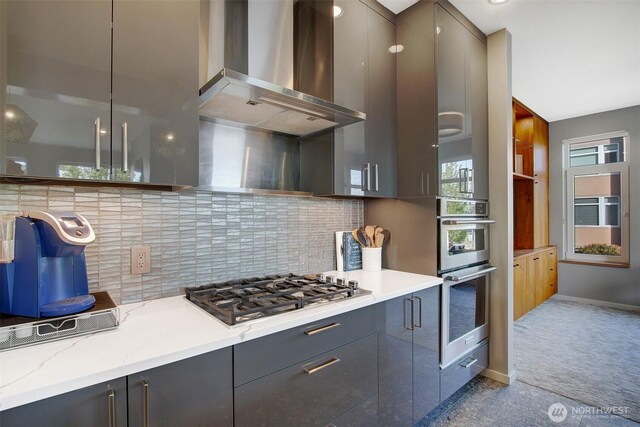 kitchen with backsplash, stainless steel appliances, modern cabinets, and wall chimney exhaust hood