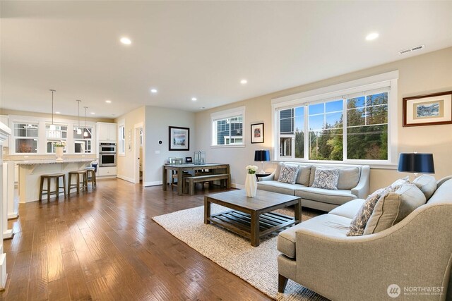 living room featuring recessed lighting, visible vents, and dark wood-type flooring