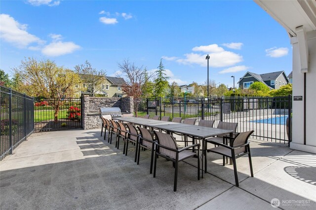view of patio / terrace featuring fence, exterior kitchen, and a residential view